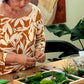 Person working on a small garden or terrarium project at a table.