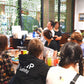 Group of people in a restaurant setting with drinks and decor.