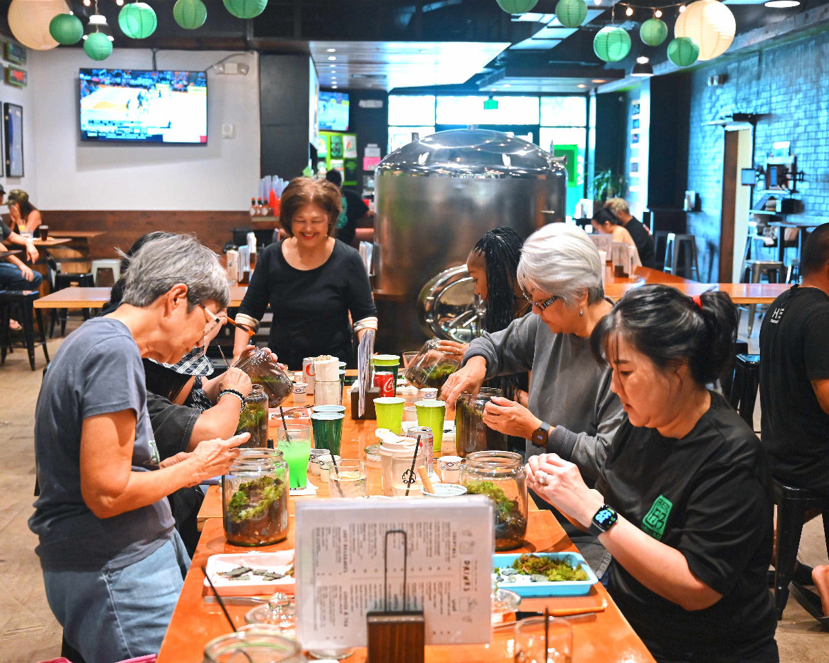 Group of people sitting around a table in a casual dining setting with drinks and food.
