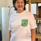 Woman wearing a white t-shirt with a colorful pocket design in a casual setting.