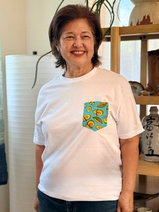 Woman wearing a white t-shirt with a colorful pocket design in a casual setting.