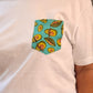 White t-shirt with a colorful avocado pattern pocket on a plain background