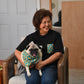 Person holding a pug in a patterned shirt in a home setting